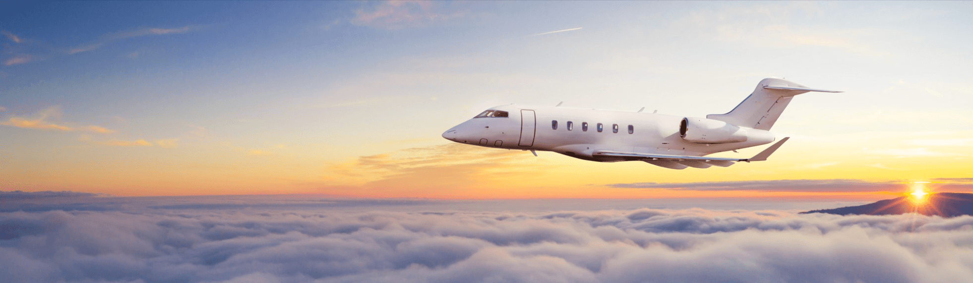 Private jet flying above clouds at sunset